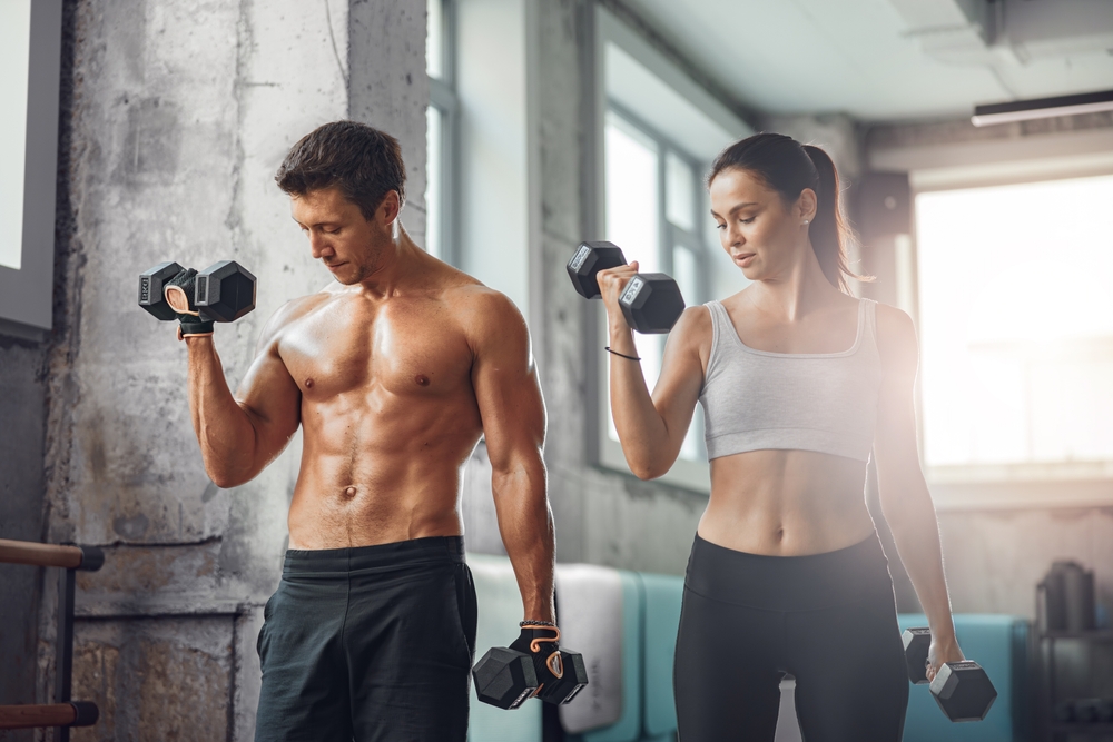 A,Fit,Couple,Lifting,Dumbbells,Harmoniously,In,A,Modern,Gym, Fitness Trainer